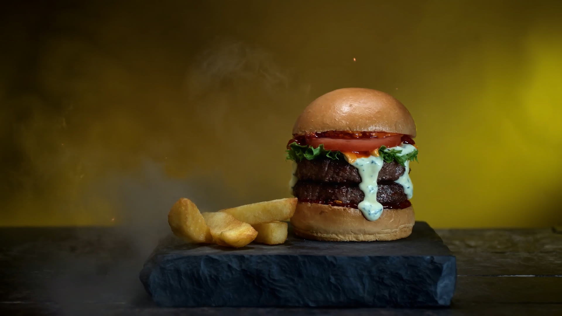 Hamburguesa doble Angus con crema de queso azul, tomate y lechuga sobre piedra oscura